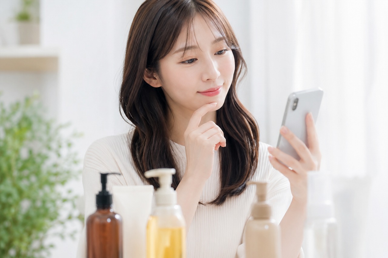 スマホでヘアケア商品を選ぶ女性イメージ