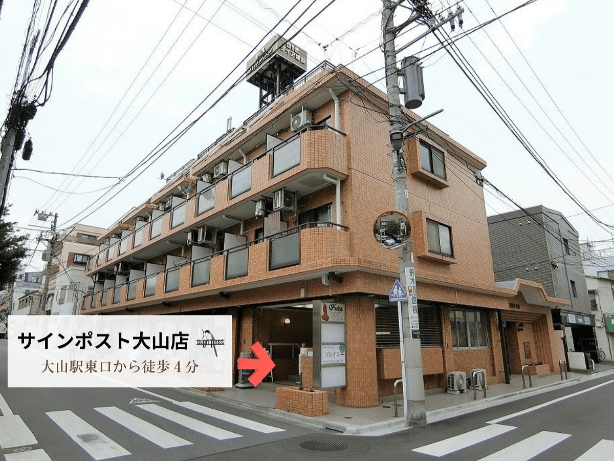 サインポスト大山店が入るダイアパレス大山の外観と地下入口の案内